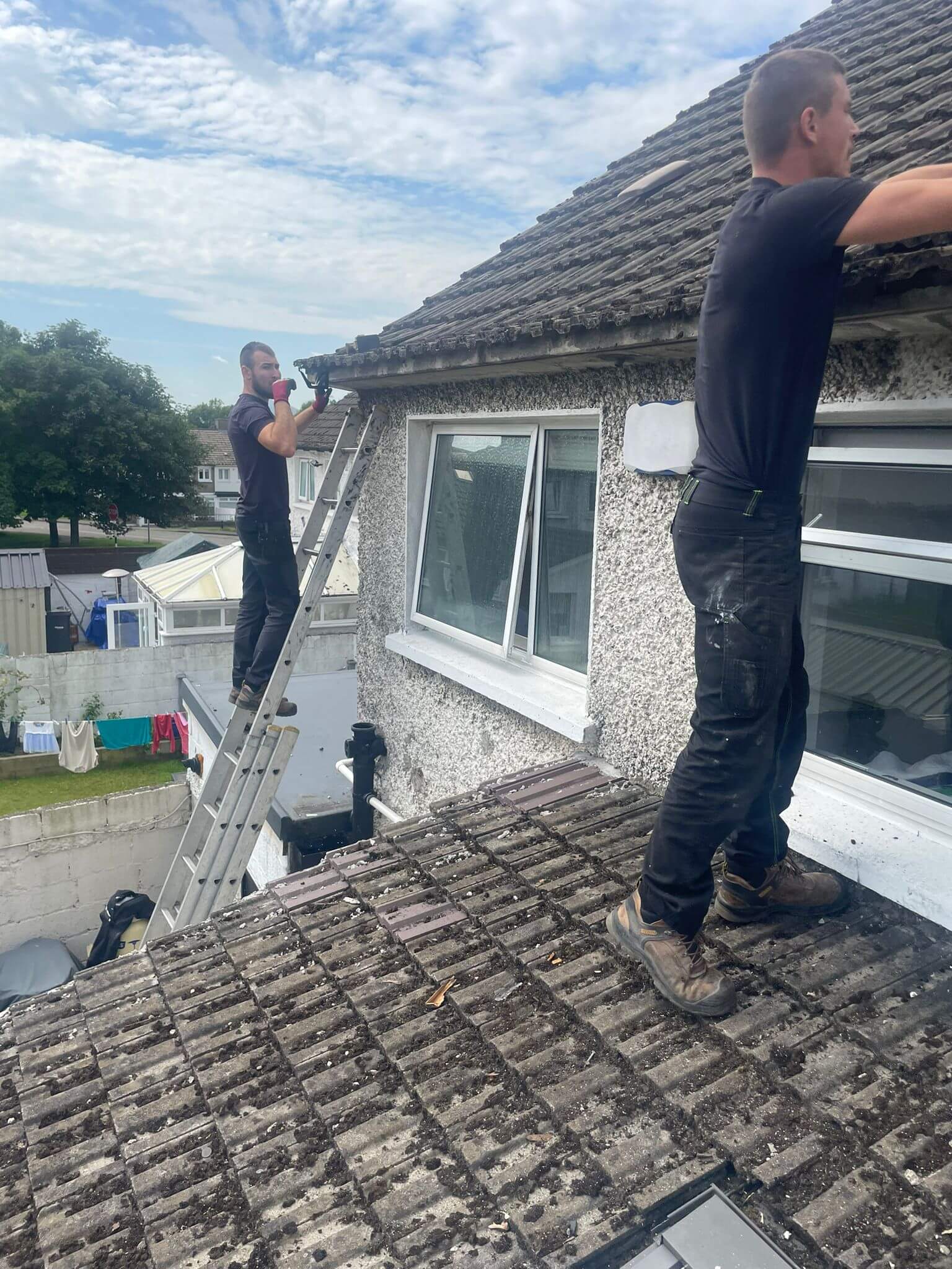 roofers installing new gutters on house